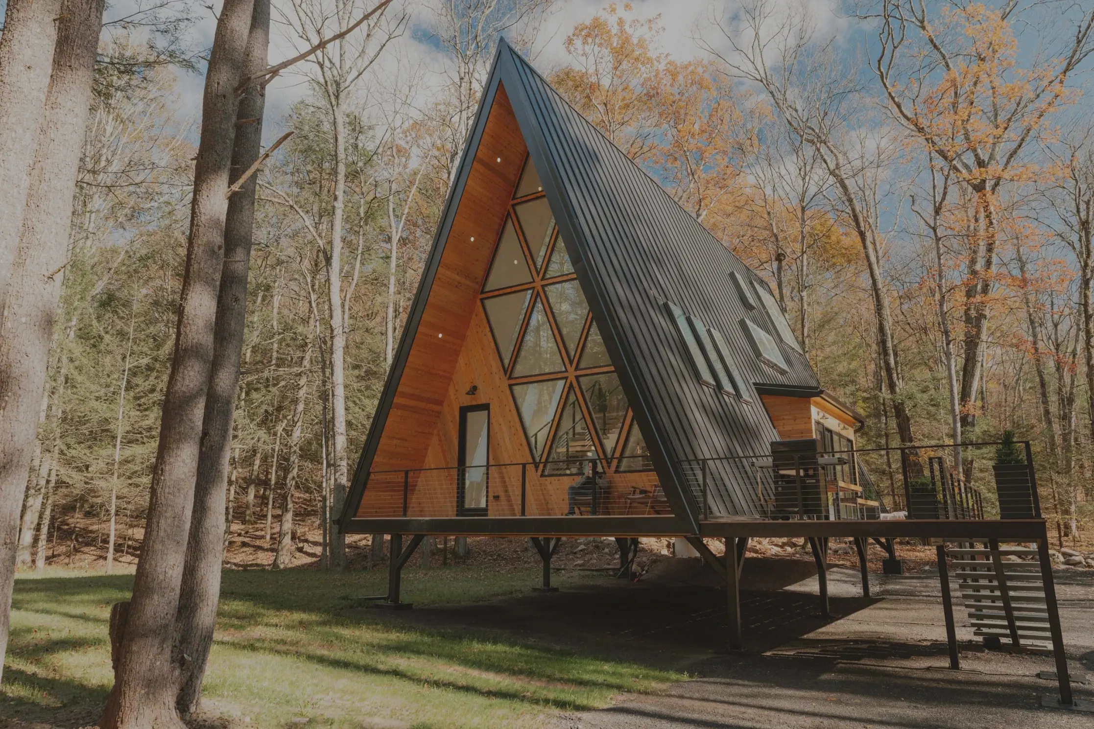 An A-frame cabin in the woods on a bright autumn day
