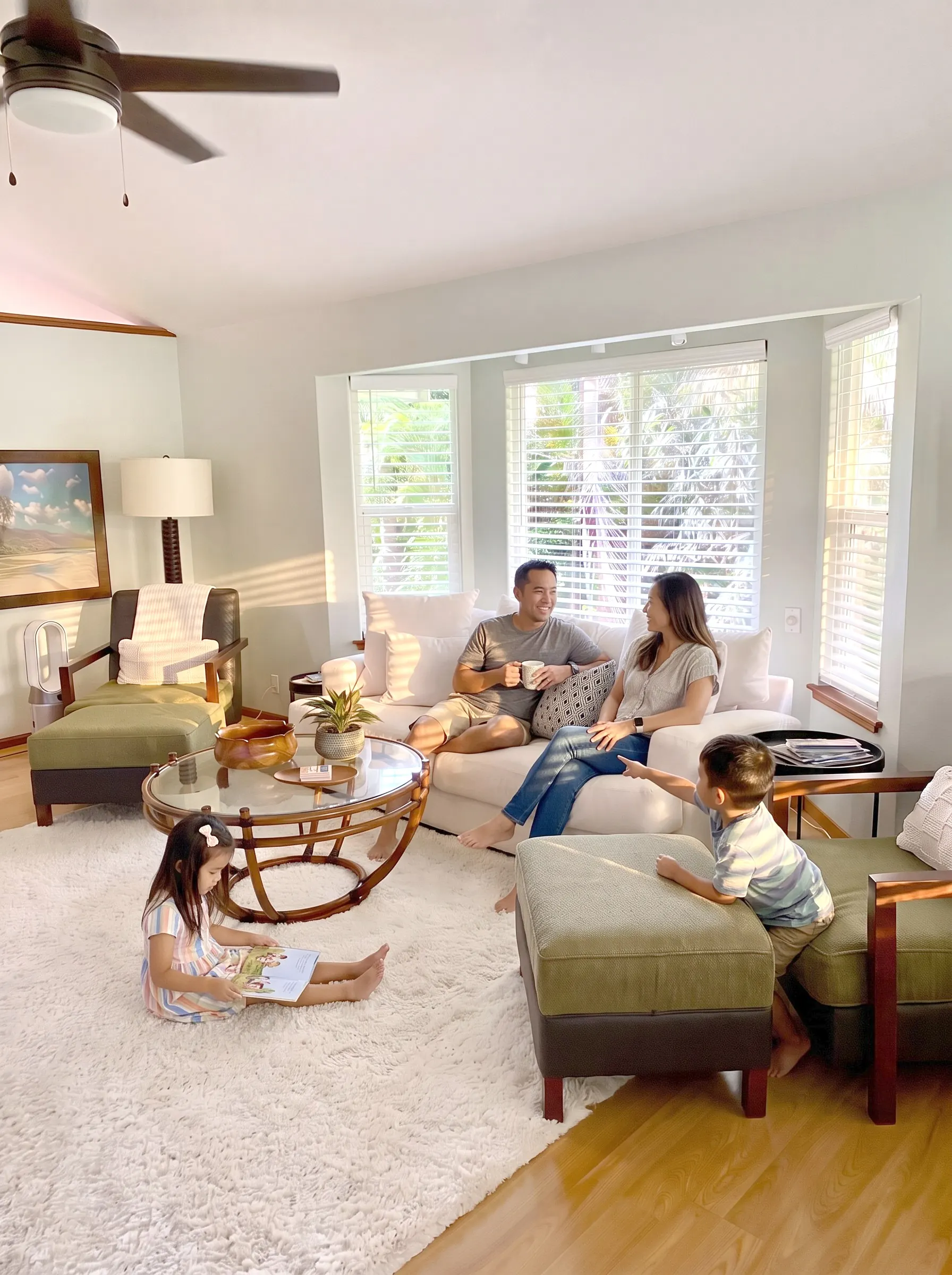 After: the same family room, sunlit and warm with a family on the sofa, every piece of furniture where it was
