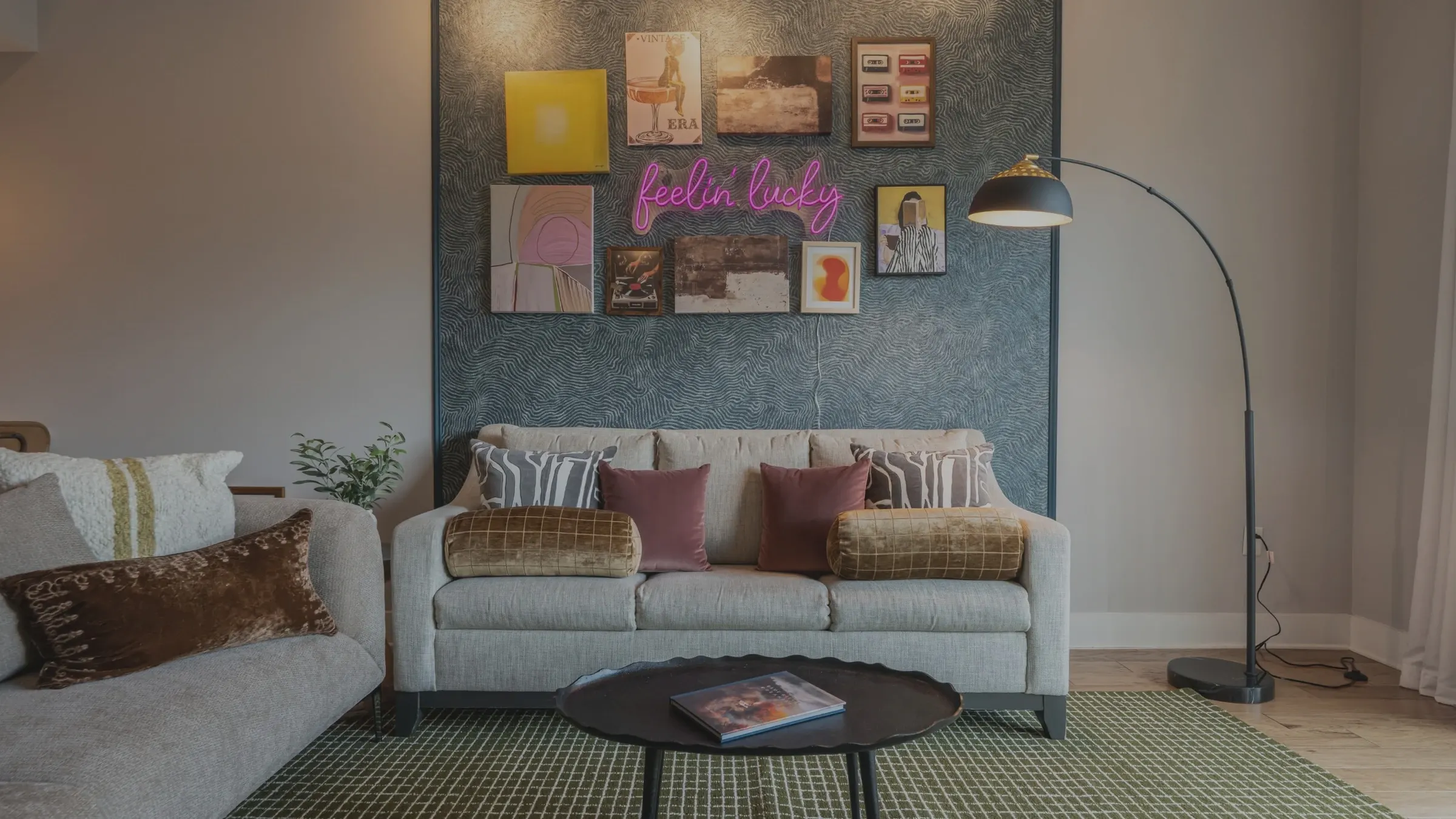 A living room in flat gray daylight, the neon sign on the wall barely visible