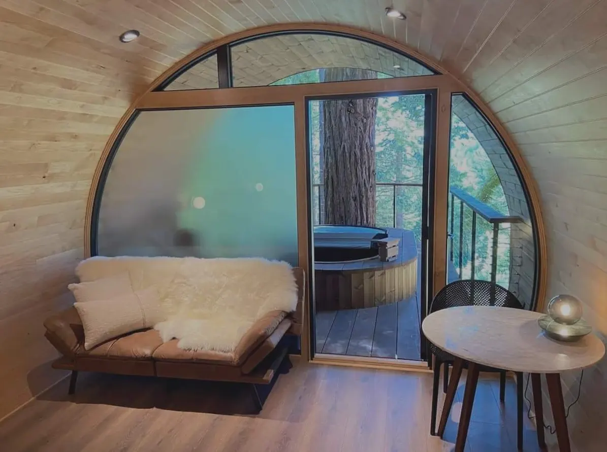 The original photo of a wood-lined cabin room with a round window wall